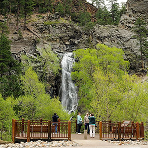 People taking photos by waterfall